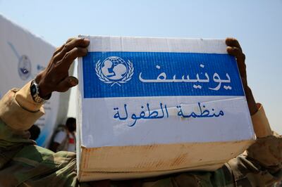 A displaced Yemeni carries a relief box donated by Unicef at a camp on the outskirts of Sanaa in June. EPA
