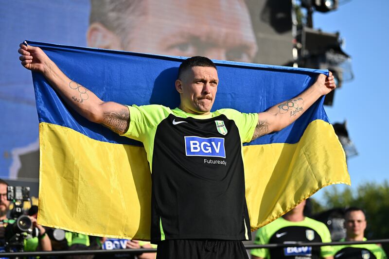 Oleksandr Usyk of Ukraine poses with his national flag ahead of his heavyweight title defence on Saturday night. EPA