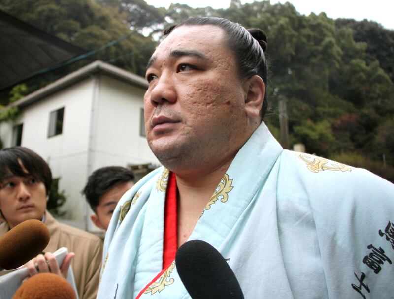 Mongolian sumo grand champion Harumafuji speaks to journalists after morning training for the ongoing Kyushu Grand Sumo Tournament in Dazaifu, southwestern Japan, Tuesday, Nov. 14, 2017. Japanese sumo officials are investigating allegations that Harumafuji hit his fellow Mongolian wrestler Takanoiwa in the head with a beer bottle at a party in October, fracturing his skull base and causing other injuries. (Kyodo News via AP)