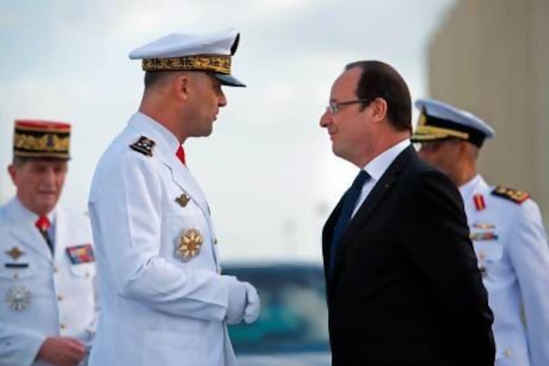 Francois Hollande, the French president, is welcomed by vice admiral Marin Gillier, left, chief of the French troops in the UAE, at the French naval base Camp de la Paix in Abu Dhabi. Bertrand Langlois / AFP