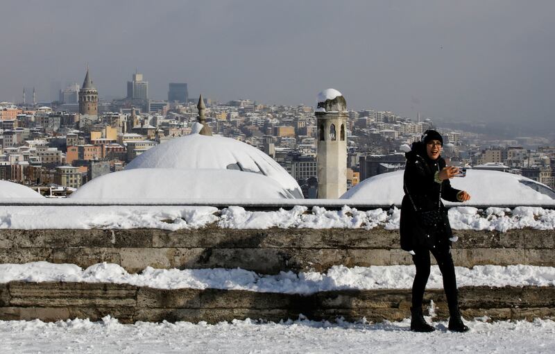 A woman enjoys the snowy day. Reuters