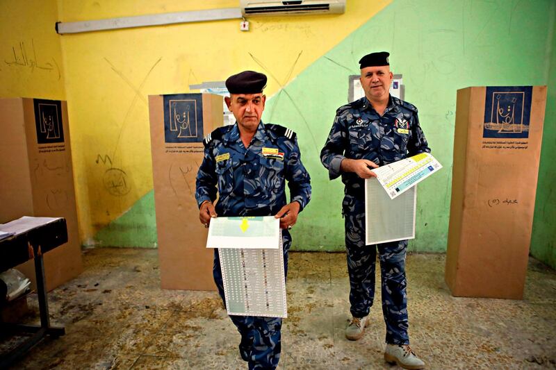 Federal policemen prepare to cast their votes at a polling station in Basra, 340 miles (550 kilometers) southeast of Baghdad, Iraq, Thursday, May 10, 2018. Soldiers and security forces cast ballots in early voting ahead of Saturday's parliamentary elections. (AP Photo/Nabil al-Jurani)