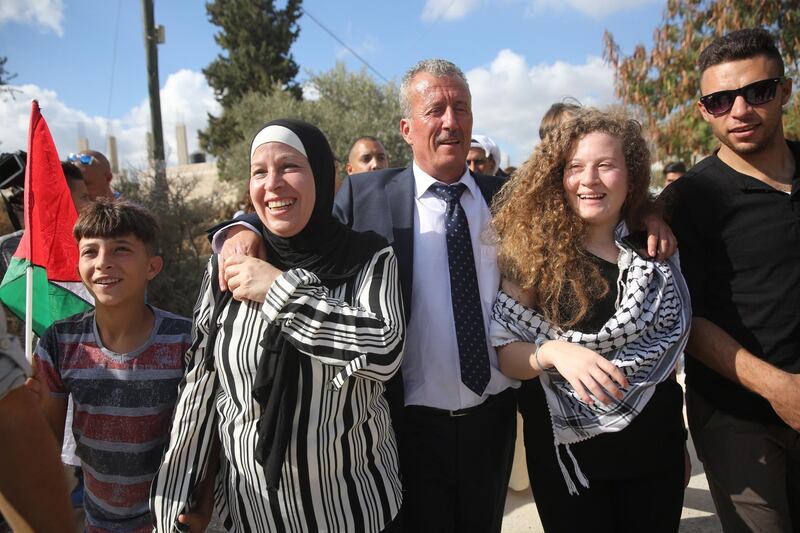 Ahed Tamimi with her parents as they walk towards her home .