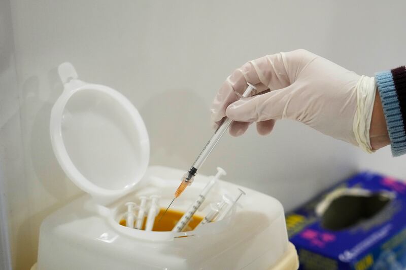 A nurse safely discards a used syringe at an Italian Red Cross Covid-19 vaccination hub in Rome. AP Photo