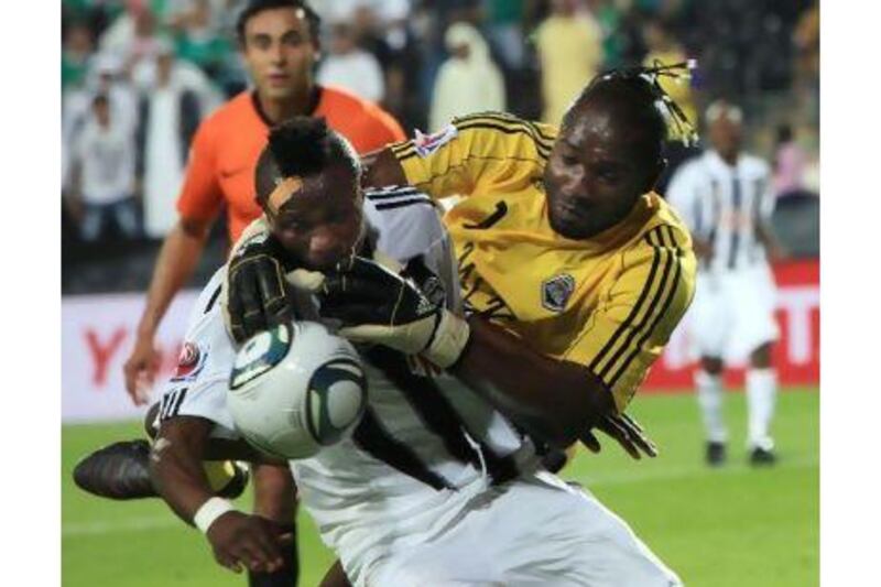 Muteba Kidiaba, the TP Mazembe goalkeeper, gets tangled up with his defender as they attempt to block a cross during their 1-0 triumph over Mexican side Pachuca in Abu Dhabi last night. Ravindranath K / The National