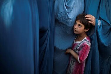 FILE PHOTO: An Afghan girl stands in line with her mother to get food package on the outskirts of Kabul, Afghanistan September 14, 2010.  REUTERS / Ahmad Masood / File Photo