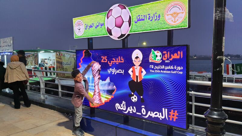 Ibrahim Mohammed poses next to a hoarding in Basra promoting the Gulf Cup, featuring Sinbad the Sailor, the mascot for the tournament. All photos: Sinan Mahmoud / The National