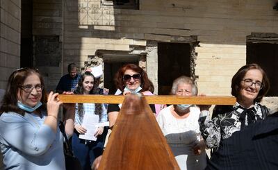 Iraqi christians carry a large cross during the inauguration ceremony for the new bell at Syriac Christian church of Mar Tuma in the country's second city of Mosul on September 18, seven years after ISIS overran the city and proclaimed it their "capital", before they were driven out three years later by the Iraqi army. AFP