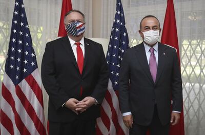 United States Secretary of State Mike Pompeo, left and Turkey's Foreign Minister Mevlut Cavusoglu pose for photos before a meeting, in Santo Domingo, Dominican Republic, Sunday, Aug. 16, 2020. Cavusoglu and Pompeo attended the swearing-in ceremony of Dominican Republic's President Luis Abinader.(Cem Ozdel/Turkish Foreign Ministry via AP, Pool )