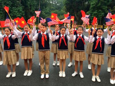 Children waves American and Vietnamese flags as they wait for U.S. President Donald Trump to arrive for a meeting with Vietnamese President Nguyen Phu Trong in Hanoi, Vietnam, Wednesday, Feb. 27, 2019. (AP Photo/Hau Dinh)