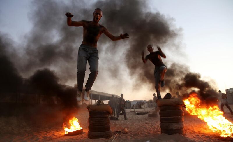 Palestinian students jump over burning tyres in a display of their military skills at Al-Rebat College for Law and Police Science in Khan Younis, southern Gaza Strip. AP Photo