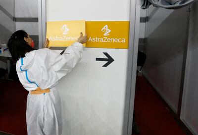 FILE - In this Sunday, March 21, 2021 file photo a medical worker wearing protective gear sets up boards with the names of the vaccines at a vaccination center in Belgrade, Serbia. Results from a U.S. trial of AstraZeneca's COVID-19 vaccine may have used "outdated information," U.S. federal health officials said early Tuesday March 23, 2021. (AP Photo/Darko Vojinovic, File)