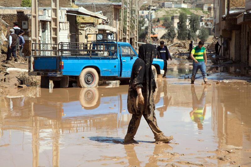 An Iranian woman walks through a flooded street in the city of Poldokhtar in the Lorestan province. AFP