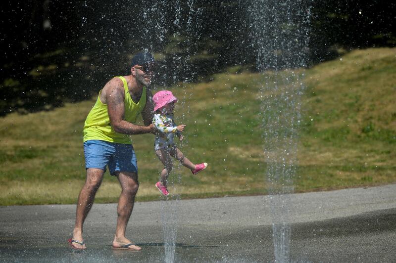Kevin Ninness and one-year-old Sierra cool off at a splash pad during the scorching weather of a heatwave in Vancouver, British Columbia, Canada June 27, 2021. REUTERS/Jennifer Gauthier