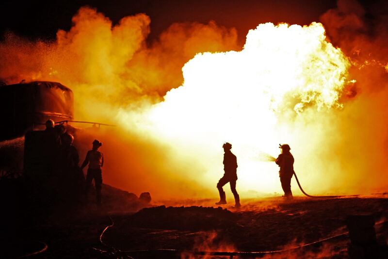 Members of the Syrian Civil Defence fight a fire which erupted after a bombardment of makeshift oil refining installations in the Tarhin area, near the Turkish-controlled city of Al Bab in the north of Aleppo province. AFP