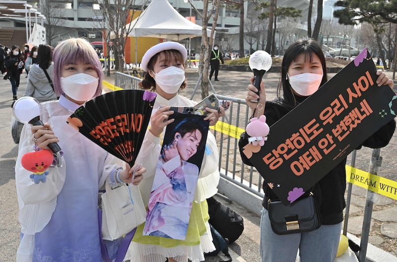 Fans of BTS hold up the group's merchandise ahead of the concert. AFP