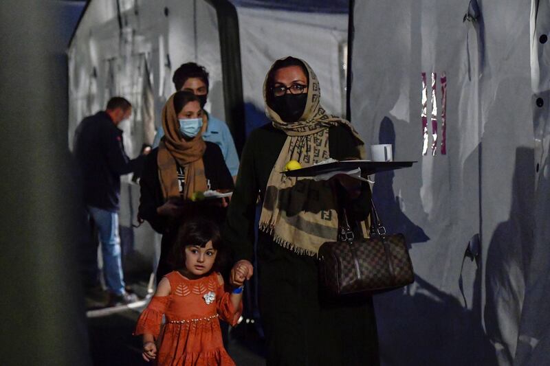 People who were evacuated from Kabul, Afghanistan, carry trays of food in Doberlug-Kirchhain, Germany. Reuters