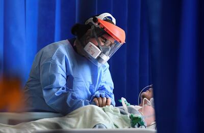 FILE - In this May 5, 2020 file photo a member of medical staff cares for a patient with coronavirus in the intensive care unit at the Royal Papworth Hospital in Cambridge, England. More than 100,000 people have died in the United Kingdom after contracting the coronavirus. That's according to government figures released Tuesday Jan. 26, 2021. Britain is the fifth country in the world to pass that mark, after the United States, Brazil, India and Mexico, and by far the smallest. The U.S. has recorded more than 400,000 COVID-19 deaths, the world's highest total, but its population of about 330 million is about five times Britain's. (Neil Hall/Pool via AP, File)