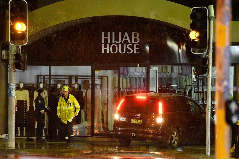 A car is removed from the Hijab House shop in south-west Sydney, Australia after it crashed through the front windows on May 21, 2020.  EPA