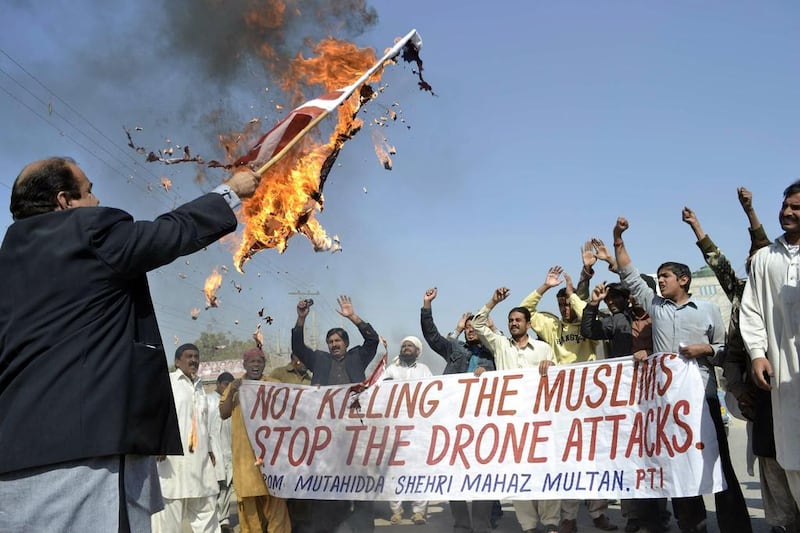A Pakistani protester holds a burning US flag during a protest in Multan last year against US drone attacks in tribal territories. US missiles killed Badar Mansoor, Al Qaeda’s chief in Pakistan, in February 2012. S S Mirza / AFP