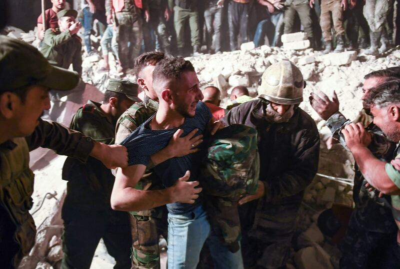 A man reacts as rescuers search for victims and survivors amidst the rubble of a building that collapsed in Syria's northern city of Aleppo, on September 7, 2022.  - Ten people were killed when a five-story building collapsed in the Ferdaws neighbourhood of Aleppo, state media said.  "The bodies of six women, three children and a man were recovered, while a child and a woman were rescued from under the rubble and taken to hospital," the official SANA news agency said.  (Photo by AFP)