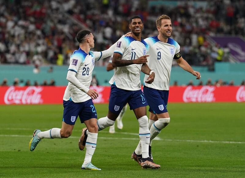 Marcus Rashford celebrates with Phil Foden and Harry Kane after adding England's fifth. PA