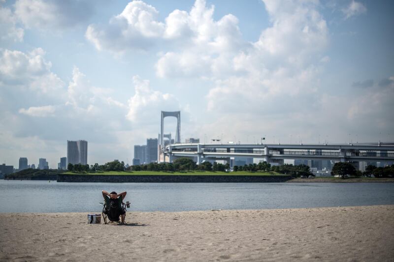 A man sunbathes in Odaiba Marine Park in Tokyo, Japan. Carl Court/Getty Images