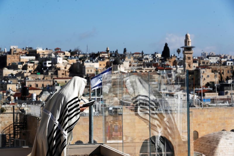 A Jewish worshipper prays on a balcony overlooking the Western Wall as a down-sized priestly blessing, a traditional prayer which usually attracts thousands of worshippers on the holiday of Passover takes place in Jerusalem's Old City. Reuters