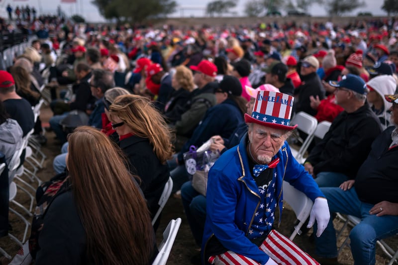 A supporter dressed as Uncle Sam listens to speakers prior to an appearance by former president Donald Trump at a rally on Saturday,  January 15, in Florence, Arizona. AP Photo