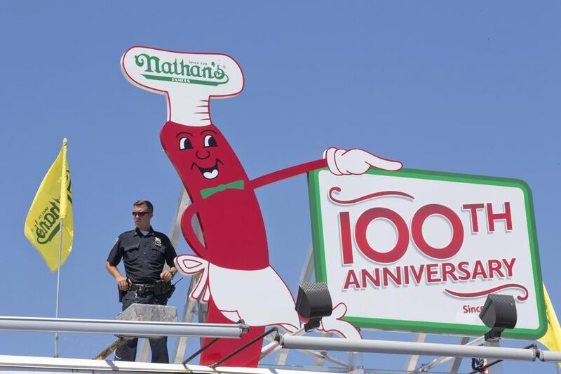 A police officer stands guard on the roof of Nathan’s Famous store. Mary Altaffer / AP Photo