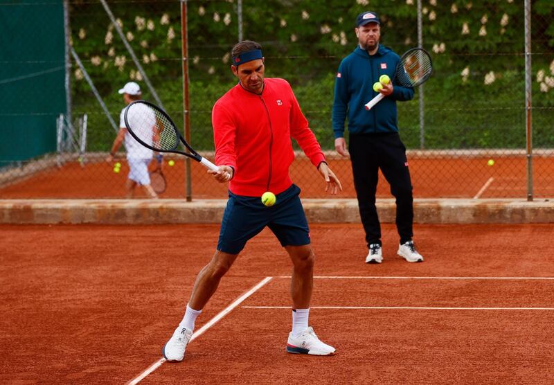 Roger Federer and coach Severin Luethi during training. Reuters