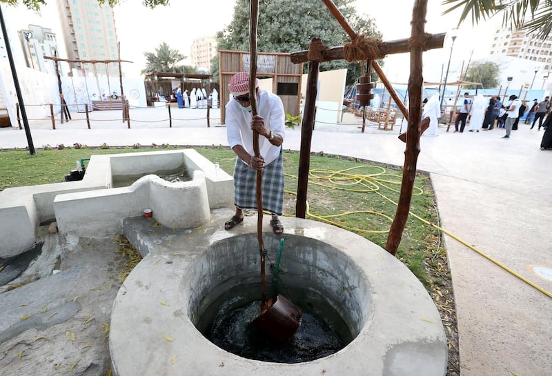 Sharjah, United Arab Emirates - Reporter: Razmig Bedirian. Arts. A man retrieves water from a well at the Heart of Sharjah for Sharjah Heritage Days. Monday, March 22nd, 2021. Sharjah. Chris Whiteoak / The National