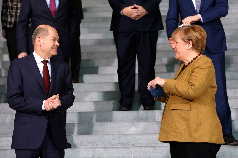Departing Chancellor Angela Merkel speaks with Olaf Scholz after her last cabinet meeting in Berlin. EPA
