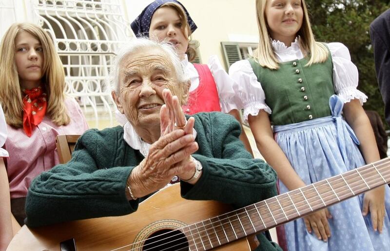 Maria von Trapp, daughter of Austrian Baron Georg von Trapp, prepares to play a guitar and sing with traditionally dressed children in front of her former home, Villa Trapp, in Salzburg in this July 2008. Reuters 
