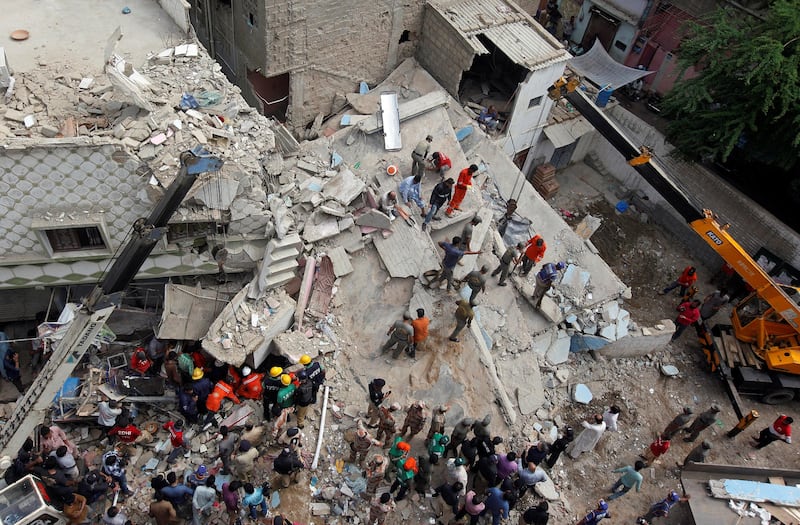 Rescue workers go through the rubble of the collapsed building. Akhtar Soomro / Reuters