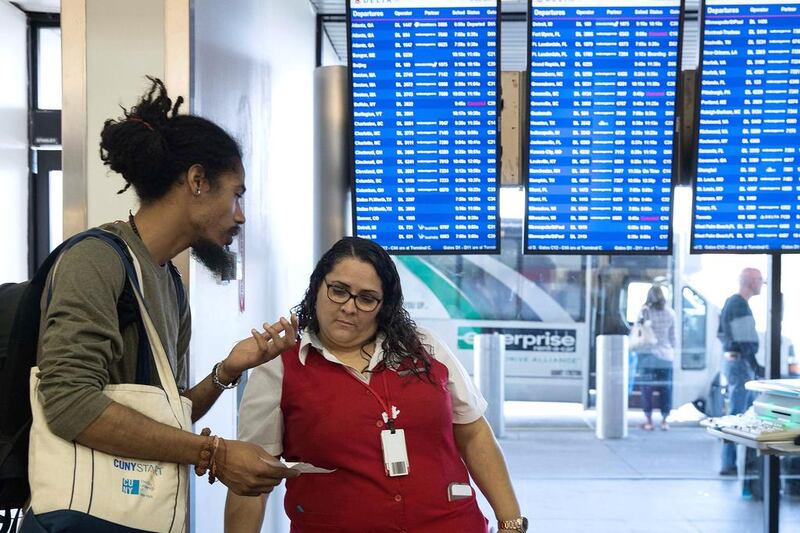 A Delta employee helps a traveller near the Delta check-in counter at LaGuardia Airport. AFP