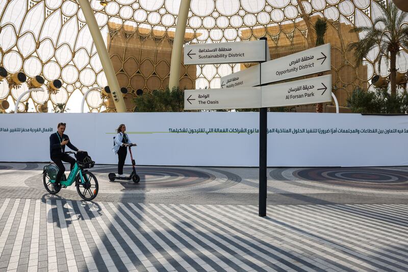 Summit attendees use an electric hire bicycle and scooter in the Green Zone. Bloomberg