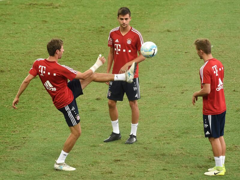 Bayern Munich's Thomas Muller (L) warms up with teammates during their official training session in Singapore on July 26, 2017, ahead of the International Champions Cup football match between Bayern Munich and Inter Milan on July 27. / AFP PHOTO / ROSLAN RAHMAN