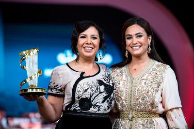 Moroccan actress Mouna Fettou (L) receives a tribute award from Tunisian actress Hend Sabry (R) during the 18th Marrakech International Film Festival on December 4, 2019 in Marrakesh. / AFP / FADEL SENNA
