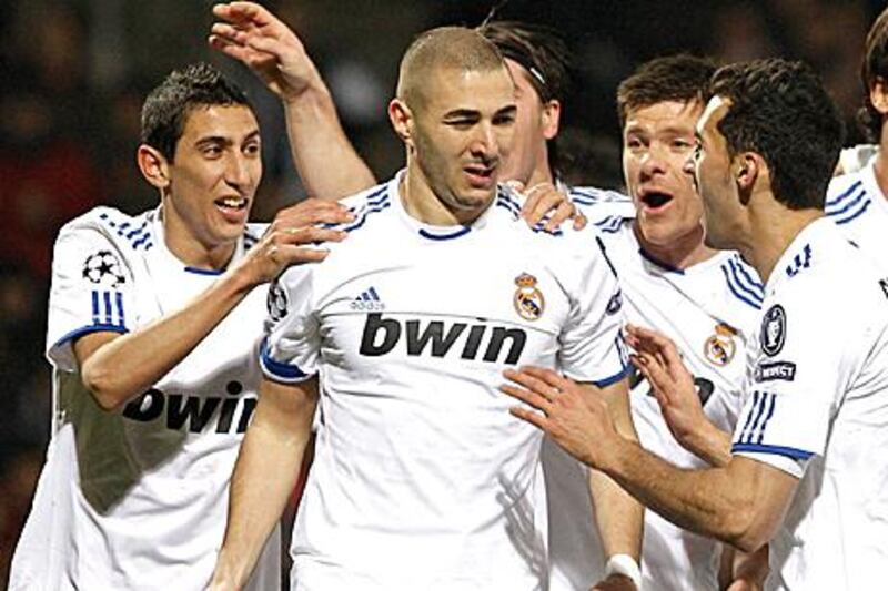Karim Benzema, centre, is congratulated by his Real Madrid teammates after putting his side 1-0 up in their 1-1 draw with Lyon.