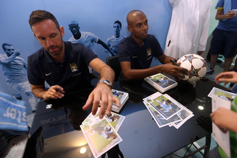 November 15, 2013 (Abu Dhabi) Manchester City footballers Feenandinho and Richard Wright sign autographs at the City Store at Marina Mall in Abu Dhabi November 15, 2013. (Sammy Dallal / The National)  *** Local Caption ***  sd-111613-football-06.jpg