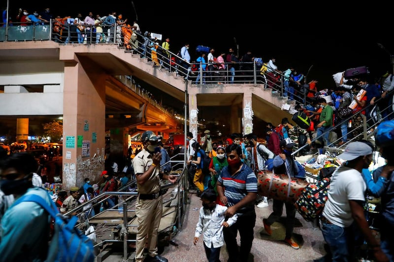 Migrant workers arrive at a bus station to board buses to return to their villages after Delhi government ordered a six-day lockdown to limit the spread of the coronavirus disease (COVID-19), in Ghaziabad on the outskirts of New Delhi, India, April 19, 2021. REUTERS/Adnan Abidi     TPX IMAGES OF THE DAY