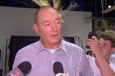 In this image made from video, a teenager breaks an egg on the head of Senator Fraser Anning while he holds a press conference, Saturday, March 16, 2019, in Melbourne, New Zealand. AP