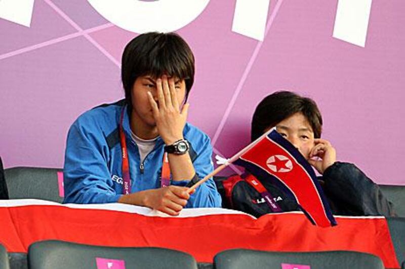 North Korean supporters wait in dismay after their women's football team left the pitch following the flag blunder by Olympic organisers.