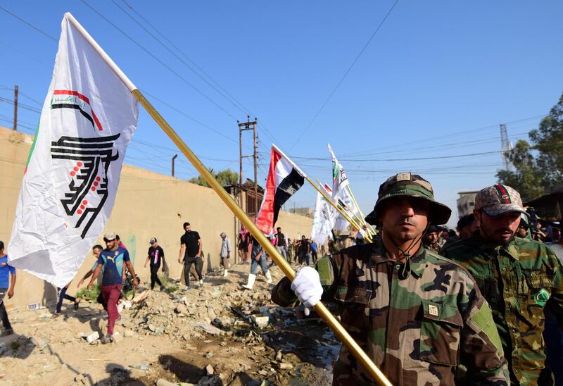 epa07794657 Members of Iran backed armed group Kataib Hezbollah (Hezbollah Brigades) carry their flag during the funeral of their leader Abu Ali al-Debbi, who was killed in a drone attack a day earlier near the Iraqi western border with Syria, at the funeral procession in Baghdad, Iraq, 26 August 2019.  Abu Ali al-Debbi, the chief of logistical support of Iraqi Hezbollah Brigades, was killed late 25 August 2019, near the western border with Syria in an Israeli drone strike in Al-Qaim while on a patrol near the Iraqi borders, Iraqi Shiite Popular Mobilization Forces said in a statement.  EPA/MURTAJA LATEEF