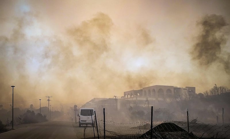 Smoke rises from a burnt hotel complex during a wildfire. AFP