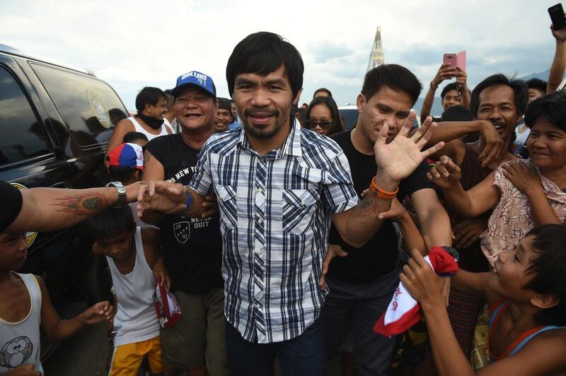 Boxing icon Manny Pacquiao is mobbed by supporters during his campaign in Calamba town, Laguna province. Ted Aljibe / AFP 