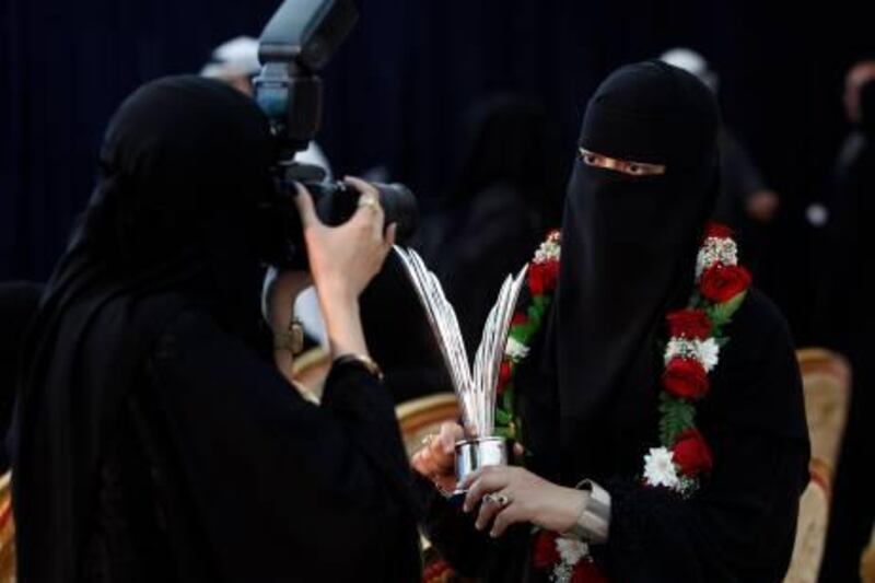 Dubai , United Arab Emirates- February, 22 , 2011:  Noora Al Moqitib (R) pose with the trophy as her sisiter Ayesha Al Moqitib takes her picture during the  Mohammed bin Rashid awards for Young Business Leaders  in Dubai.   ( Satish Kumar / The National )