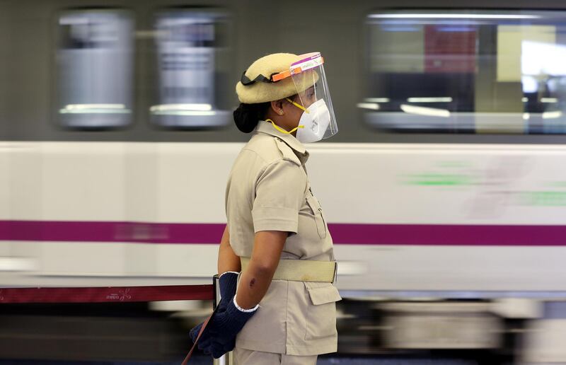 Member of the Bengaluru Metro security staff wear mask and face shield to protect herself from the pandemic stand guard at city metro station in south Indian city of Bengaluru.  EPA