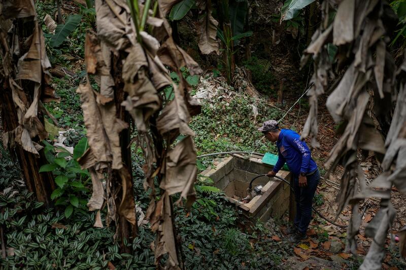 Franklin Caceres checks a water pump used to collect water from a well in the Petare neighborhood of Caracas, Venezuela. Caceres supplies water to more than 400 people. AP Photo